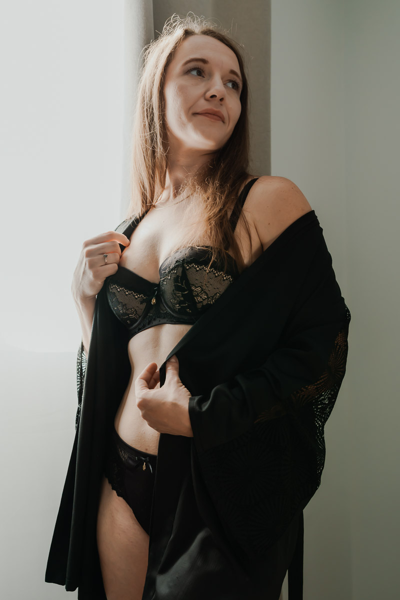 Boudoir en déshabillé noir près d'une fenêtre