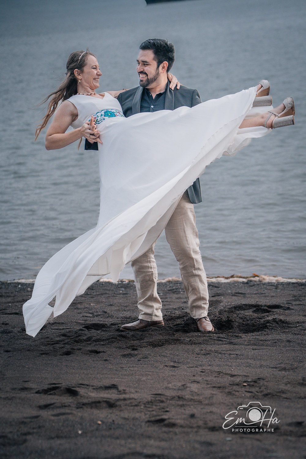 Marié portant sa mariée sur la plage