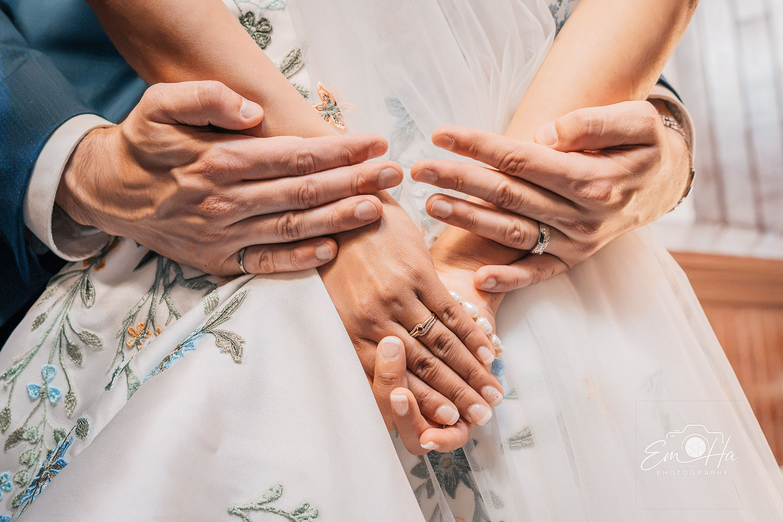 Mains jointes sur le bouquet de la mariée